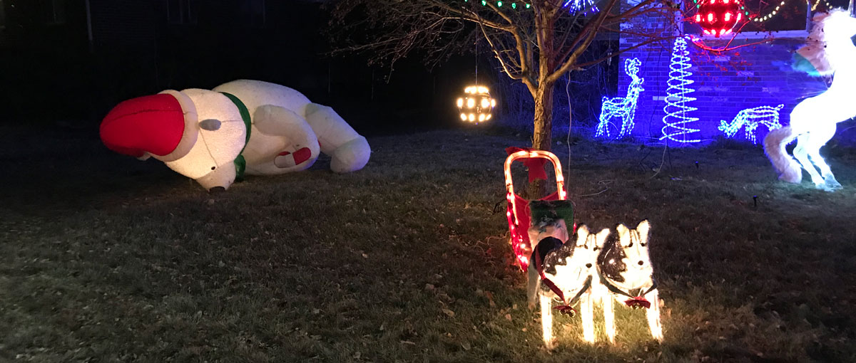de-inflated christmas decorations on a front lawn